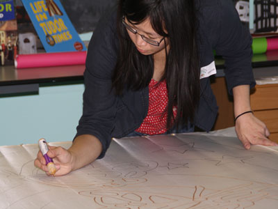 Applying gutta to the hand-drawn designs on the silk banner pieces...